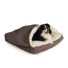 Cozy Cave Rectangle Dog Bed in brown with a happy dog snuggling inside, featuring soft Sherpa lining and durable fabric.