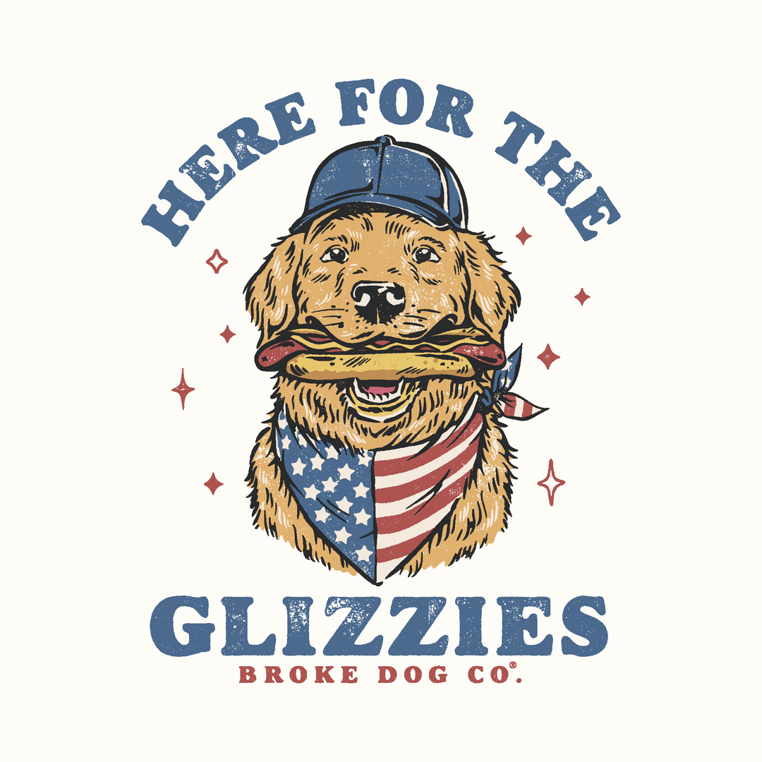 Illustration of a golden retriever wearing a cap and bandana, holding a hot dog, promoting 'Here for the Glizzies' t-shirt.